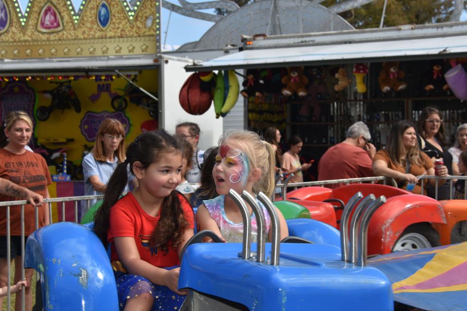 Melanie Fonseca, age 4 and Eleanor Rodrigue ride the tractor ride at the fair during the Larose French Food Festival, October 29.