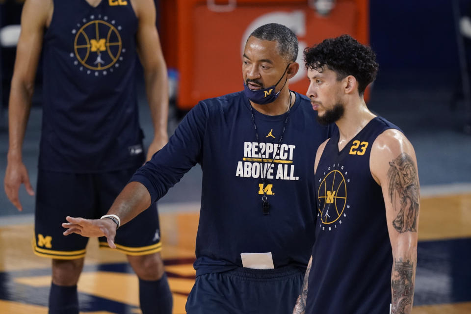 Michigan head basketball coach Juwan Howard, front left, talks with forward Brandon Johns Jr. (23) during an NCAA college basketball practice during media day, Friday, Oct. 15, 2021, in Ann Arbor, Mich. (AP Photo/Carlos Osorio)