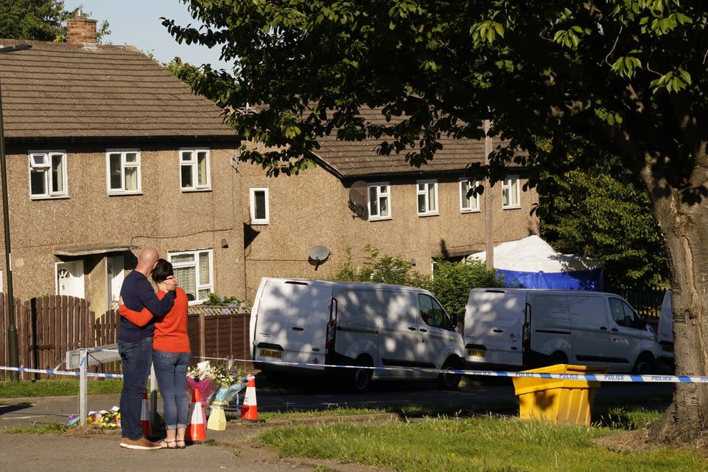 The father of some of the victims leaves flowers at the scene in Chandos Crescent, Killamarsh, near Sheffield (PA) (PA Wire)