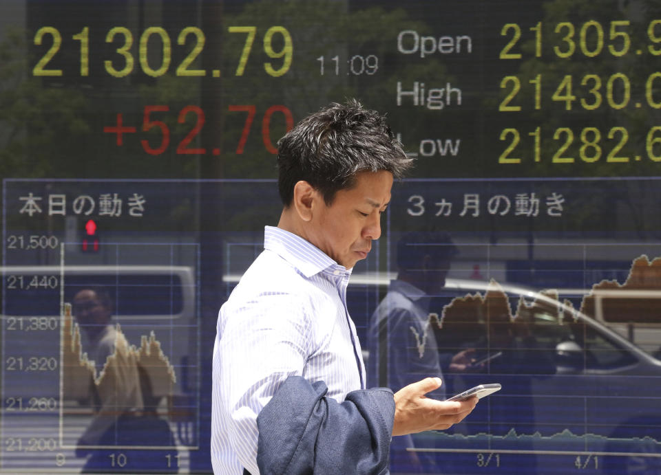 A man walks by an electronic stock board of a securities firm in Tokyo, Monday, May 20, 2019. Shares are mixed in Asia, with India and Australia leading gains following elections that look set to keep incumbents in office.(AP Photo/Koji Sasahara)