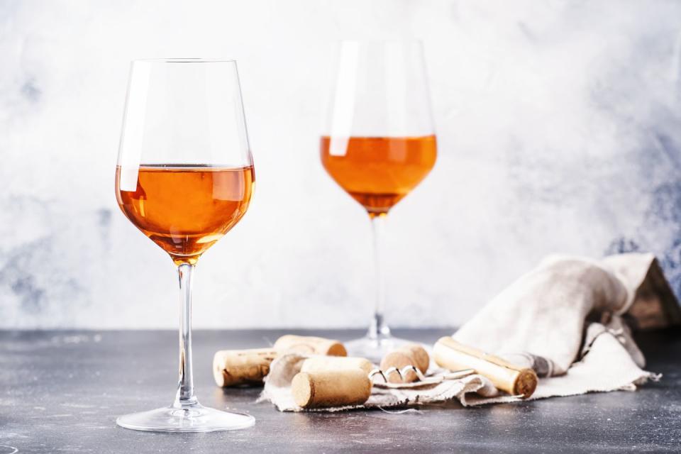 trendy food and drink, orange wine in glass, gray table
