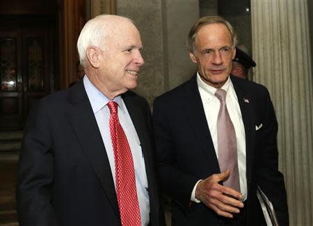 Senators John McCain (R-AZ) (L) and Thomas Carper (D-DE) talk outside of the Senate chamber after voting on the U.S. budget bill in Washington December 18, 2013. REUTERS/Gary Cameron