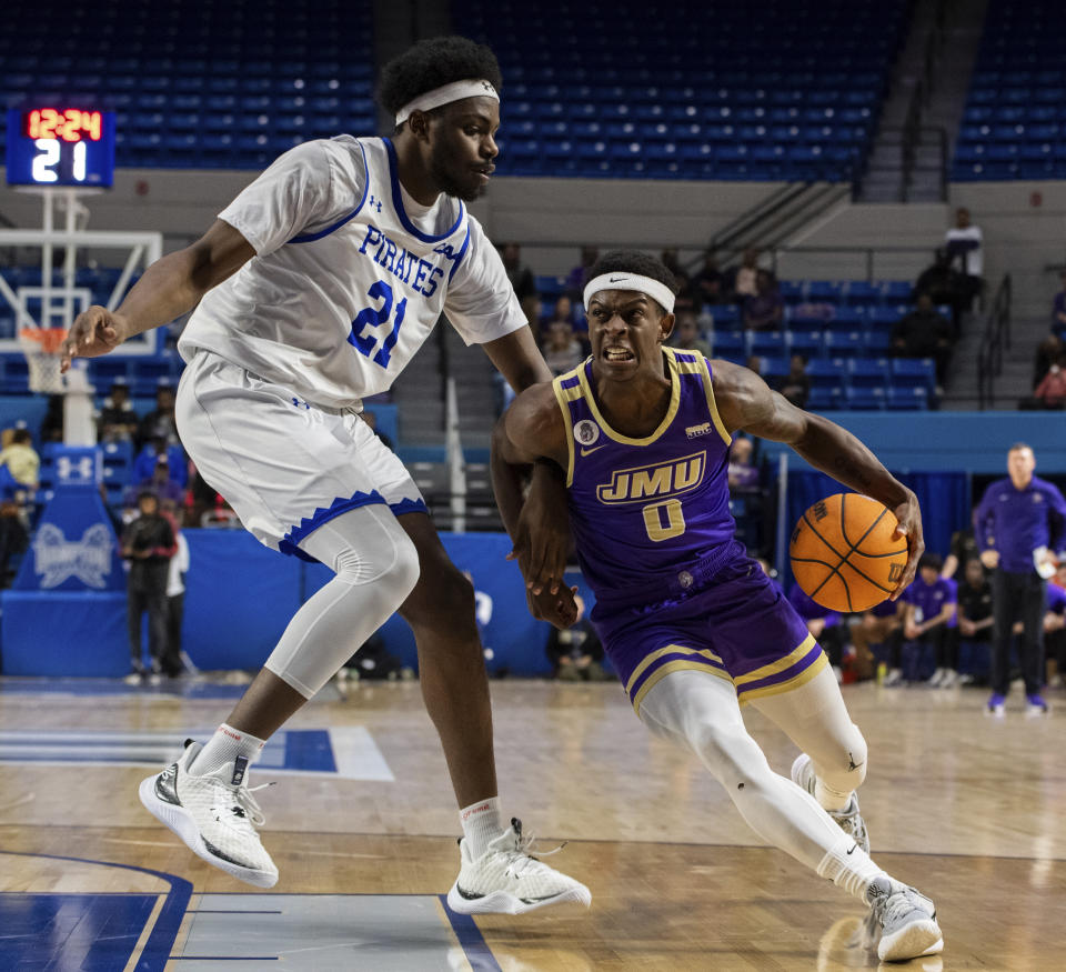 James Madison guard Xavier Brown (0) dribbles towards the basket against Hampton forward Ja'Von Benson (21) during the first half of an NCAA college basketball game Saturday, Dec. 16, 2023, in Hampton, Va. (AP Photo/Mike Caudill)