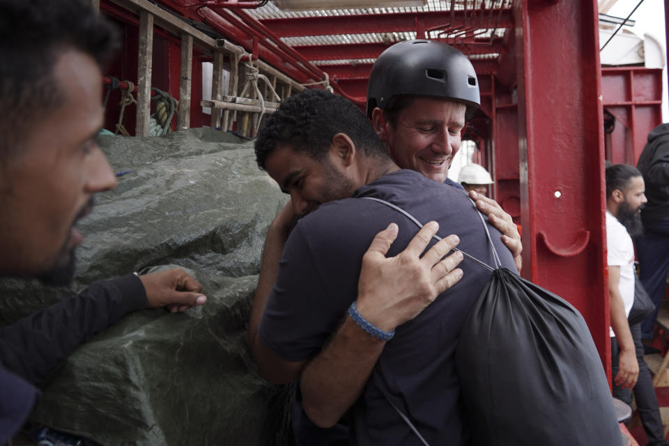 A migrant hugs an SOS Mediterranee rescuer aboard the Ocean Viking ship before stepping into the port of Messina, Italy, Tuesday, Sept. 24, 2019. He was among 182 people aboard the Ocean Viking rescued in the Mediterranean Sea north of Libya. (AP Photo/Renata Brito)