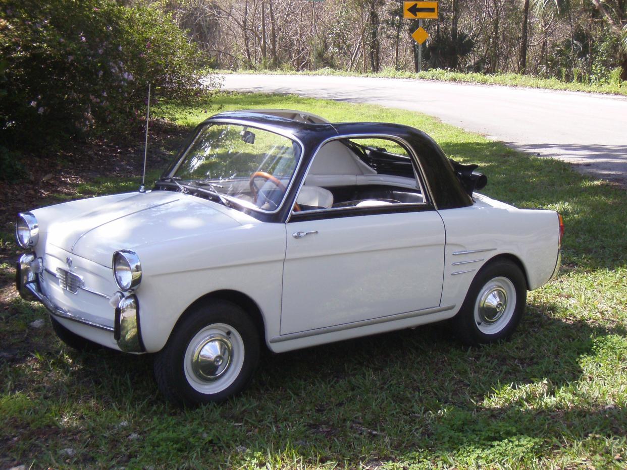 White 1961 Autobianchi Bianchina Trasformabile parked on a green lawn off a road