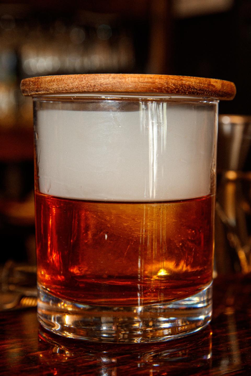 An old fashioned is smoked for a few seconds to enhance the flavor and profile of the drink at American Barrel in Columbia, Tenn. on Apr. 20, 2023. 