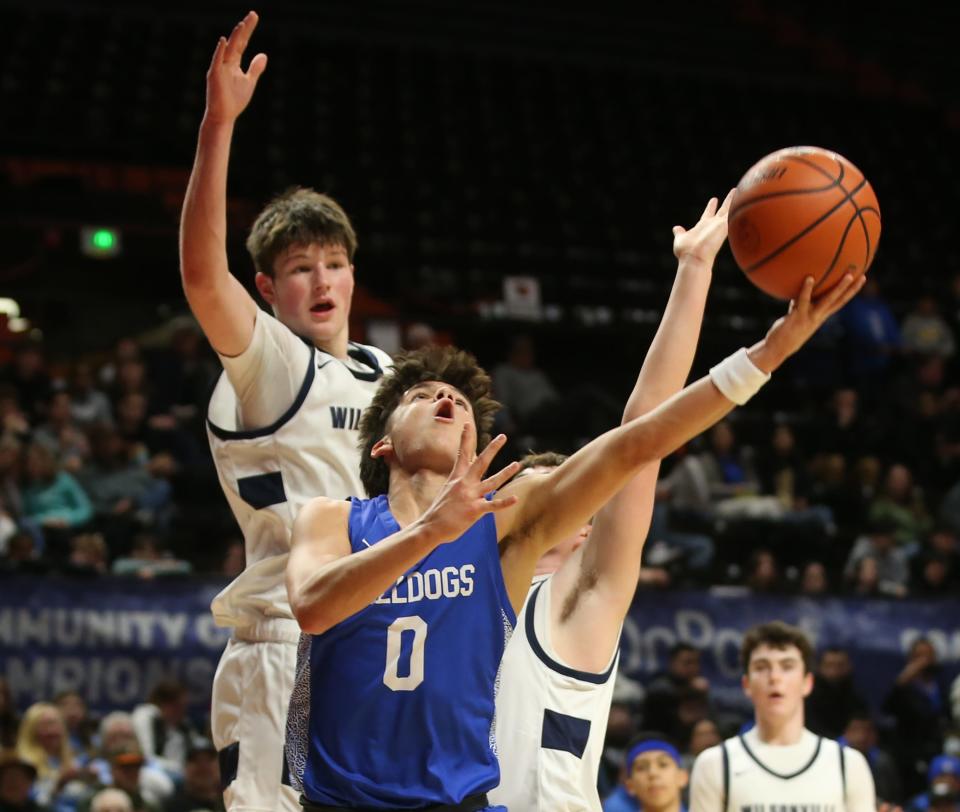 Woodburn's Cruz Veliz, center, takes a shot ahead of the Wilsonville defense during the first half of the OSAA 5A state basketball quarterfinals game at Gill Coliseum in Corvallis on Wednesday, March 8, 2023.