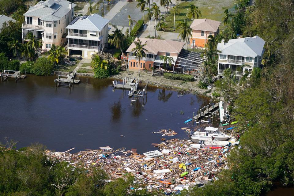 This aerial photo shows damaged homes and debris in the aftermath of Hurricane Ian, Thursday, Sept. 29, 2022, in Fort Myers, Fla. (AP Photo/Wilfredo Lee)