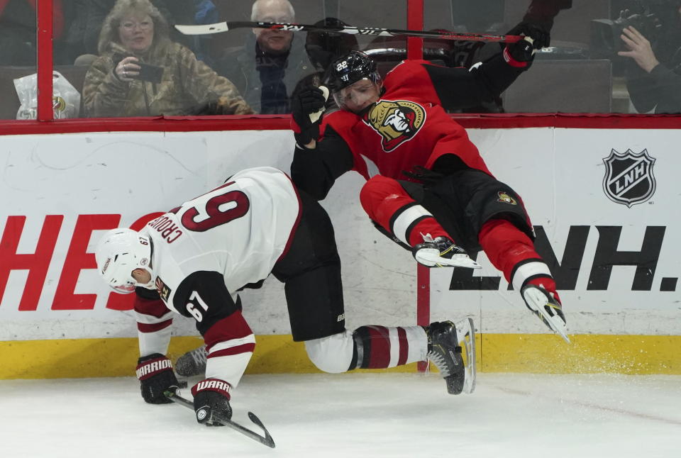 Ottawa Senators defenseman Nikita Zaitsev (22) crashes to the ice while fighting for the puck with Arizona Coyotes left wing Lawson Crouse (67) during third-period NHL hockey game action in Ottawa, Ontario, Thursday, Feb. 13, 2020. (Chris Wattie/The Canadian Press via AP)