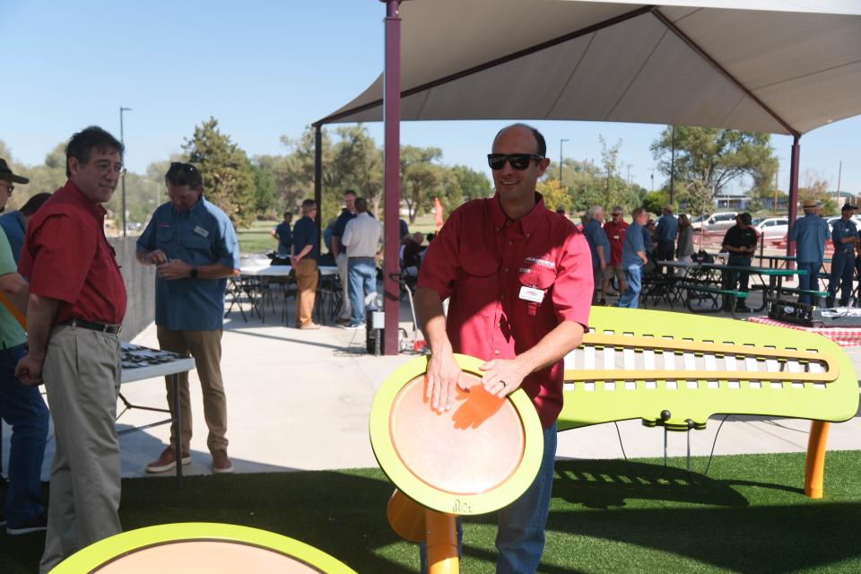 Matt Truelove, an AMBUCS member, shows off the music component of the newly built Kylie Hiner Memorial Park Thursday in Canyon.