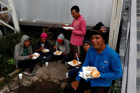 A group of migrants from Honduras, part of the caravan traveling from Central America en route to the United States, eats donated food at a sport centre used as a shelter, in Mexico City, Mexico November 4, 2018. REUTERS/Henry Romero