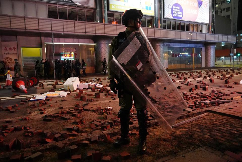 Police arrive on a street laid with bricks by protesters in Hong Kong, Wednesday, Jan. 1, 2020. Hong Kong toned down its New Year’s celebrations amid the protests that began in June and which have dealt severe blows to the city’s retail, tourism and nightlife sectors. (AP Photo/Vincent Yu)