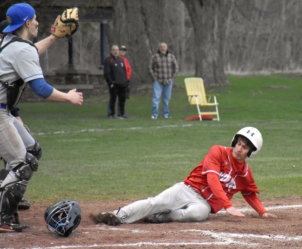 Oppenheim-Ephratah-St. Johnsville runner Ian Smith (right) slides home safely ahead of a throw during Thursday's third inning against Mayfield.