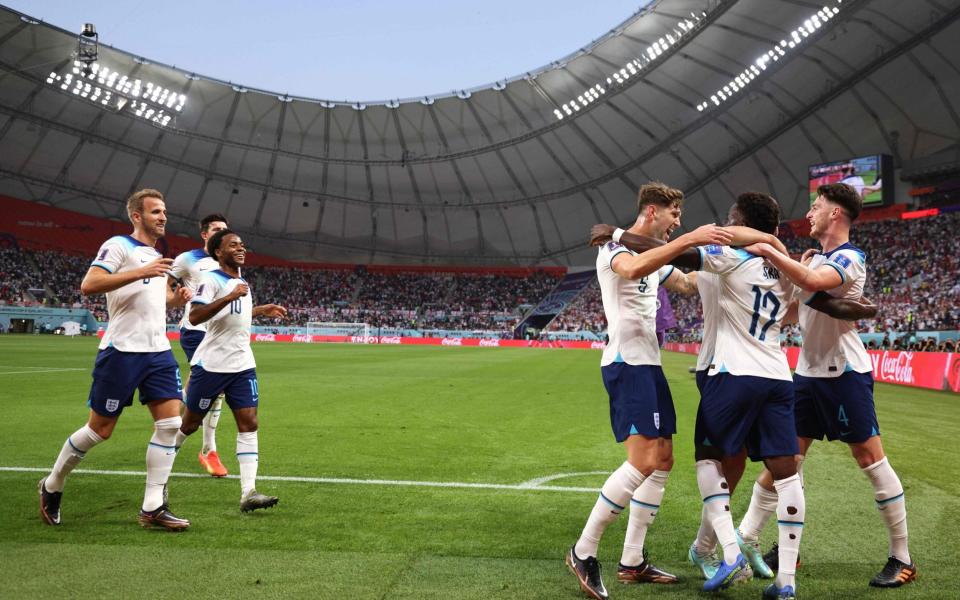 England's forward #17 Bukayo Saka (2R) celebrates with teammates after scoring his team's second goal during the Qatar 2022 World Cup Group B football match between England and Iran at the Khalifa International Stadium in Doha on November 21, 2022. - ADRIAN DENNIS/AFP