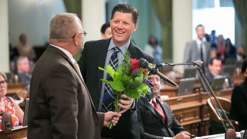 SACRAMENTO, CALIF. -- THURSDAY, SEPTEMBER 10, 2015: Assembly member Brian W. Jones (R-Santee) hands Assembly member Tom Lackey (R-Palmdale) a bouquet, in Sacramento, Calif., on Sept. 10, 2015. (Marcus Yam / Los Angeles Times)