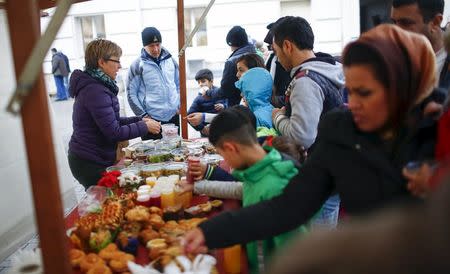 Migrants receive food at a Christmas market at a refugee shelter run by German charity organisation Arbeiter Samariter Bund ASB in Berlin, Germany, December 12, 2015. REUTERS/Hannibal Hanschke