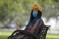 Jasmin Pierre poses for a photo with her smartphone app, in New Orleans, Thursday, July 2, 2020. Pierre, who survived multiple suicide attempts, doesn't want people struggling alone. She created The Safe Place, a free Black-oriented mental health app that's seen more signups during the pandemic. (AP Photo/Gerald Herbert)