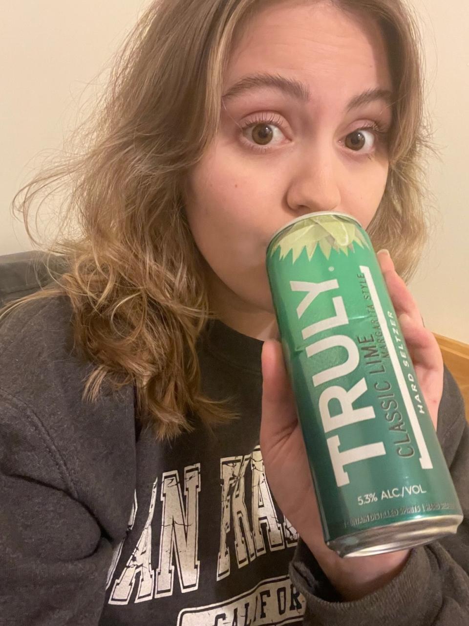 woman sipping a lime margarita seltzer