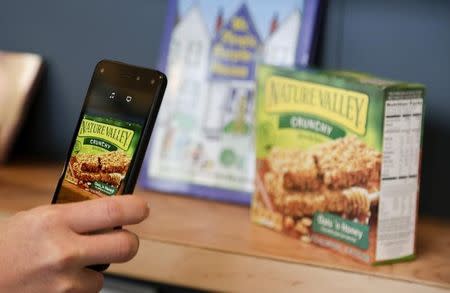 An Amazon representative shows off the Firefly scanning feature on the company's new Fire smartphone at the company's campus in Seattle, Washington June 18, 2014. REUTERS/Jason Redmond