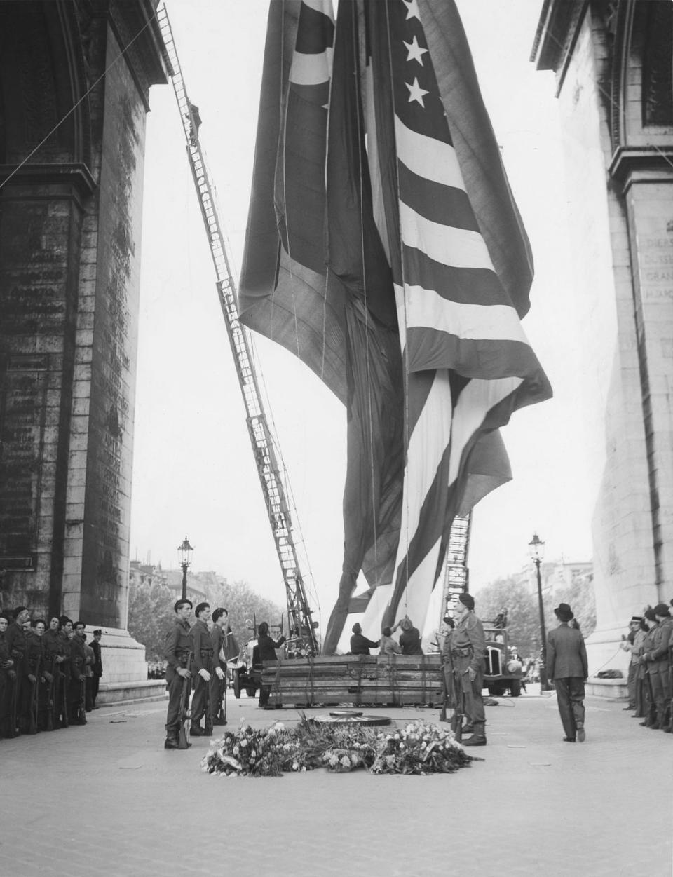 <p>The flags of Russia, France, China, Great Britain, and the United States are hoisted inside Paris' famous Arc de Triomphe following the surrender announcement.</p>