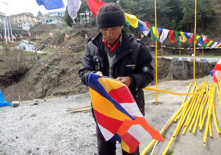 A man prepares flags to welcome Tibetan spiritual leader Dalai Lama in Tawang, Arunachal Pradesh, April 4, 2017. REUTERS/Sunil Kataria