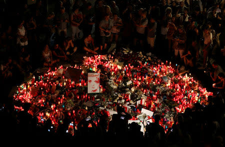 Personas se reúnen alrededor de un memorial improvisado en Barcelona. 18 de agosto de 2017. REUTERS/Sergio Perez