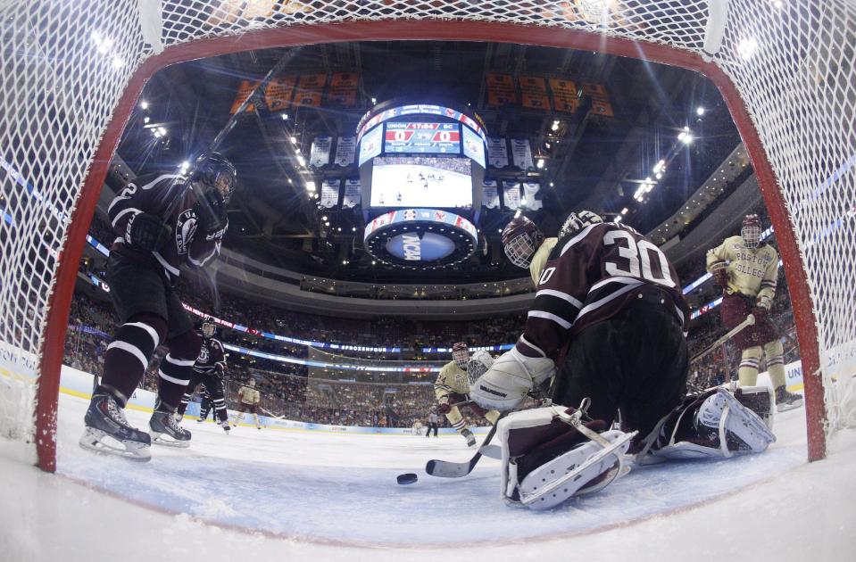 Boston College's Johnny Gaudreau, center, tips the puck past Union's Colin Stevens, right, for a goal during the first period of an NCAA men's college hockey Frozen Four tournament semifinal, Thursday, April 10, 2014, in Philadelphia. (AP Photo/Chris Szagola)