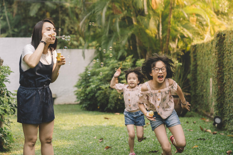A family playing with bubbles outside