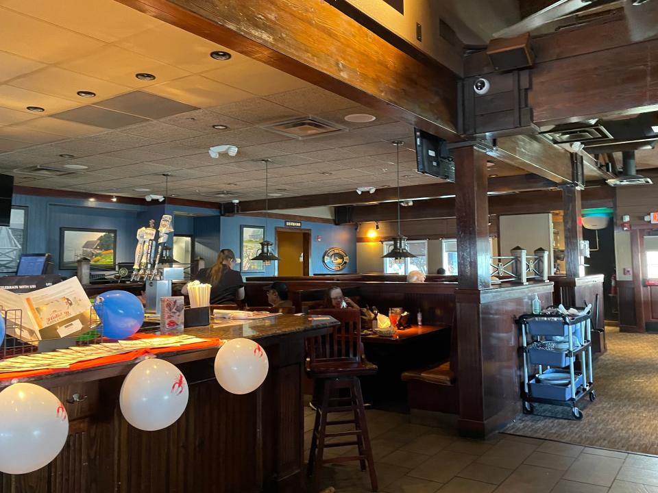 Interior of Red Lobster with dark wooden ceilings, tables, and balloons near the entrance