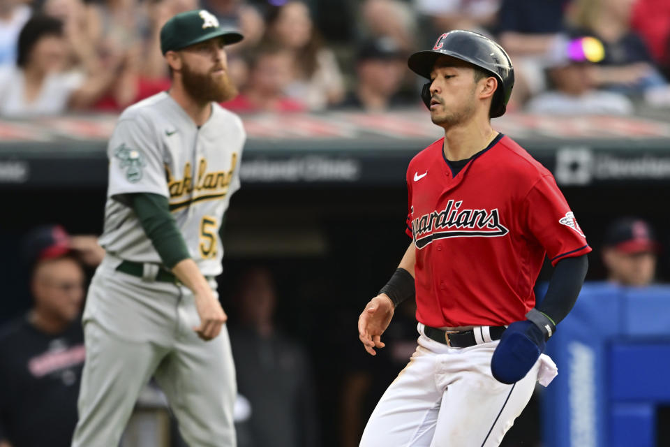 Cleveland Guardians' Steven Kwan scores next to Oakland Athletics pitcher Paul Blackburn during the third inning of a baseball game, Wednesday, June 21, 2023, in Cleveland. (AP Photo/David Dermer)