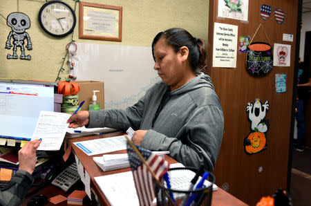 Sherri Two Horses submits an application for an absentee ballot to the Sioux County Auditor's office on the Standing Rock Reservation in Fort Yates, North Dakota, U.S. October 26, 2018. REUTERS/Dan Koeck