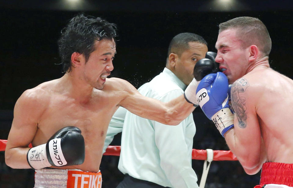 Japanese champion Shinsuke Yamanaka, left, hits his left on the face of Belgian challenger Stephane Jamoye in the seventh round in their WBC bantamweight boxing title bout in Osaka, western Japan, Wednesday, April 23, 2014. Yamanaka defended his title with a technical knockout in the ninth round. (AP Photo/Kyodo News) JAPAN OUT, CREDIT MANDATORY