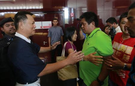 An upset relative of a passenger of the missing Malaysia Airlines flight MH370 approaches an official at a hotel in Putrajaya March 9, 2014. REUTERS/Samsul Said