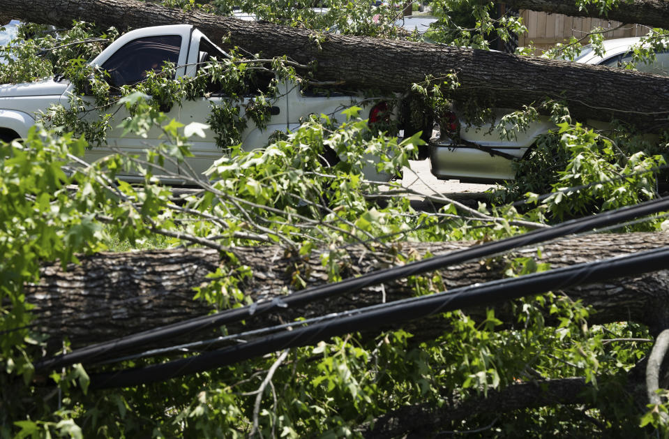 Tree branches that fell during Hurricane Beryl took down power lines and a Jeep in Acres Homes in Houston, on Wednesday, July 10, 2024. ( Elizabeth Conley/Houston Chronicle via AP)