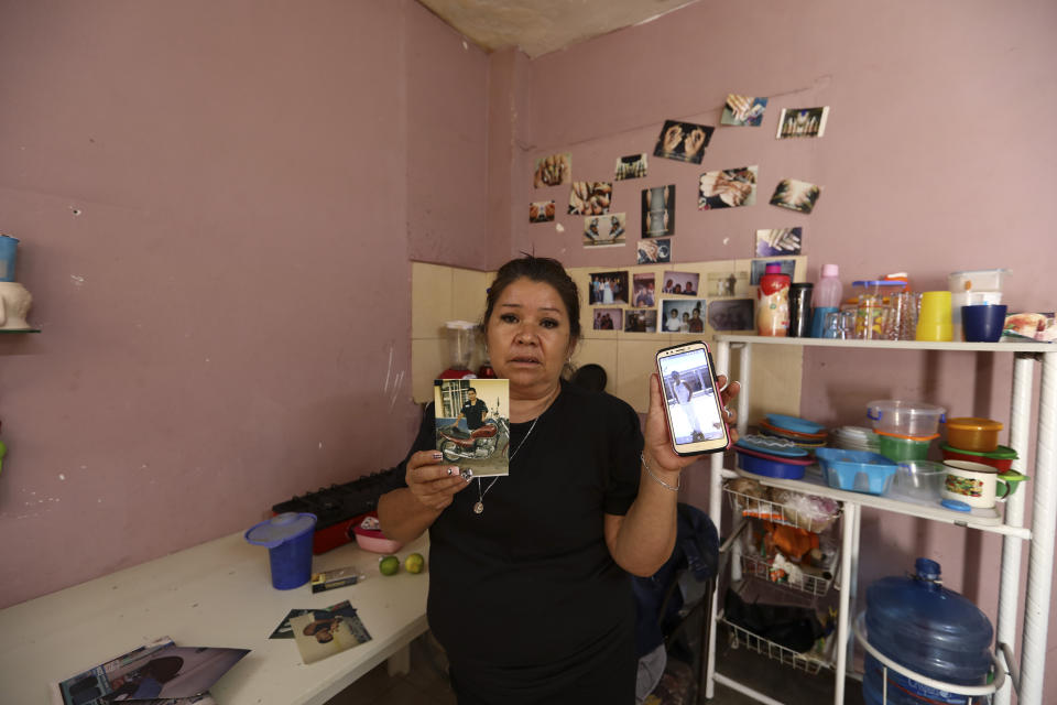 Rosa Alba Santoyo shows photos of two of her three adult children who died during an attack on the drug rehabilitation center where they were being treated, at her home in Irapuato, Mexico, Thursday, July 2, 2020. Gunmen burst into the drug rehabilitation center and opened fire Wednesday, killing 24 people and wounding seven, authorities said. (AP Photo/Eduardo Verdugo)