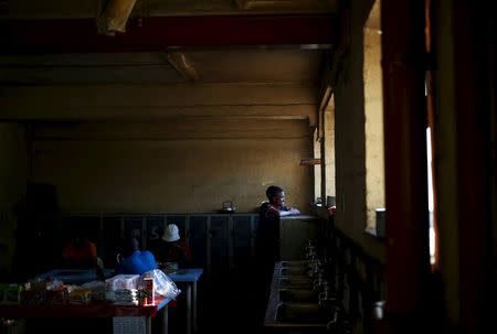 A man looks out of the window of a communal kitchen at Jeppestown men's hostel in Johannesburg May 19, 2015. REUTERS/Siphiwe Sibeko