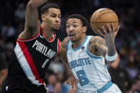 Charlotte Hornets guard Nick Smith Jr. (8) drives to the basket while guarded by Portland Trail Blazers forward Kris Murray (8) during the first half of an NBA basketball game Wednesday, April 3, 2024, in Charlotte, N.C. (AP Photo/Jacob Kupferman)