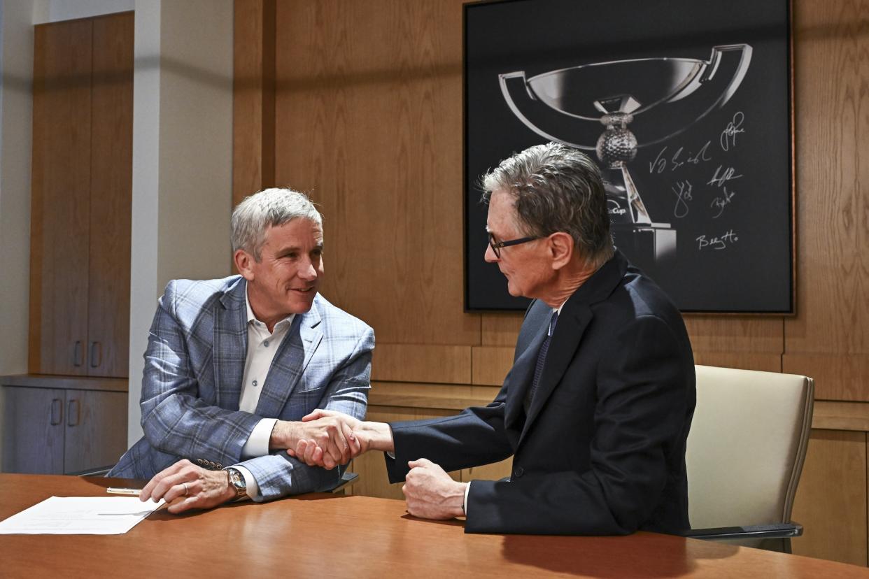 PGA Tour commissioner Jay Monahan (L) and Red Sox owner John Henry shake hands on Wednesday after signing an agreement to launch PGA Tour Enterprises. (Chris Condon/PGA Tour via Getty Images)