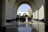 Mourners pray over the body of a person who died from COVID-19, at the Behesht-e-Zahra cemetery on the outskirts of the Iranian capital, Tehran, Iran, Sunday, Nov. 1, 2020. The cemetery is struggling to keep up with the coronavirus pandemic ravaging Iran, with double the usual number of bodies arriving each day and grave diggers excavating thousands of new plots. (AP Photo/Ebrahim Noroozi)