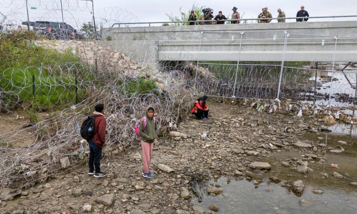 <span>US soldiers and law enforcement officers watch over a group of people who had crossed the Rio Grande into the US in Eagle Pass, Texas.</span><span>Photograph: John Moore/Getty</span>