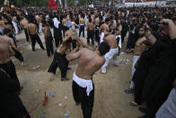 Shiite Muslims flagellate themselves with knives on chains during a Muharram procession, in Islamabad, Pakistan, Monday, Aug. 8, 2022. Muharram, the first month of the Islamic calendar, is a month of mourning for Shiites in remembrance of the death of Hussein, the grandson of the Prophet Muhammad, at the Battle of Karbala in present-day Iraq in the 7th century. (AP Photo/Anjum Naveed)