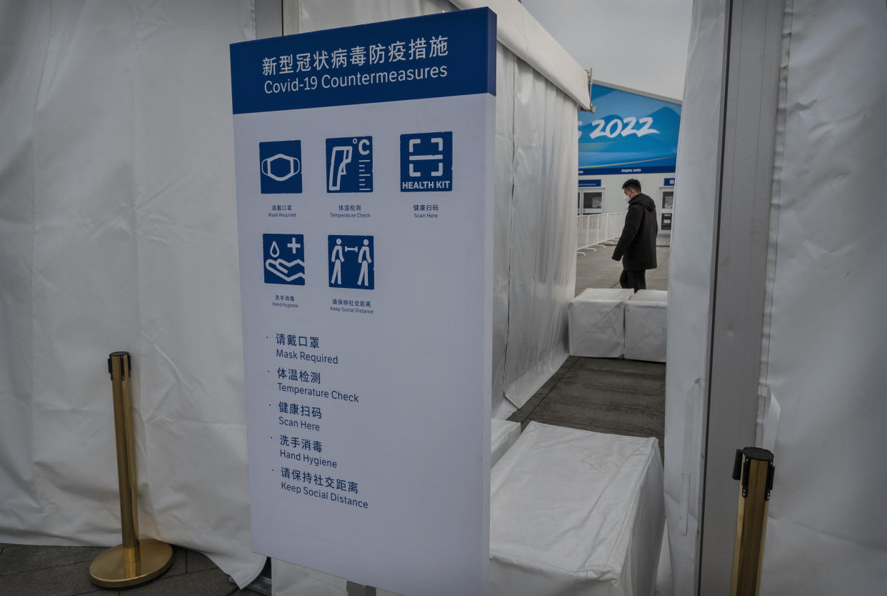 BEIJING, CHINA - JANUARY 19: A list of COVID prevention measures are seen on a sign at a security check outside a fenced area next to the National Stadium, also known as the Bird