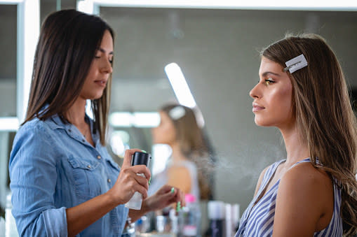 makeup artist spraying a model with spray