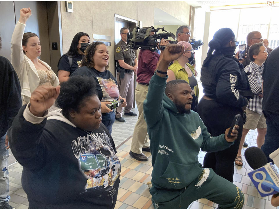 Pro-Patrick Lyoya protesters kneel and chant in the hallway outside the courtroom after police officer Christopher Schurr is arraigned on a charge of second-degree murder in Lyoya's death Friday, June 10, 2022 in Grand Rapids, Mich. (AP Photo/John Flesher)