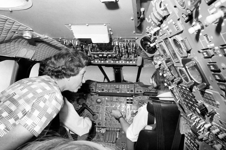 Queen Elizabeth II taking a close look at the crowded banks of instruments when she paid a visit to the flight deck of Concorde during her flight home from Bridgetown, Barbados, in the supersonic jetliner after her Silver Jubilee tour of the West Indies.