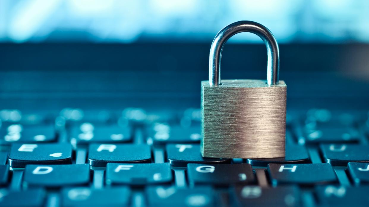  A physical lock resting on a laptop keyboard. 