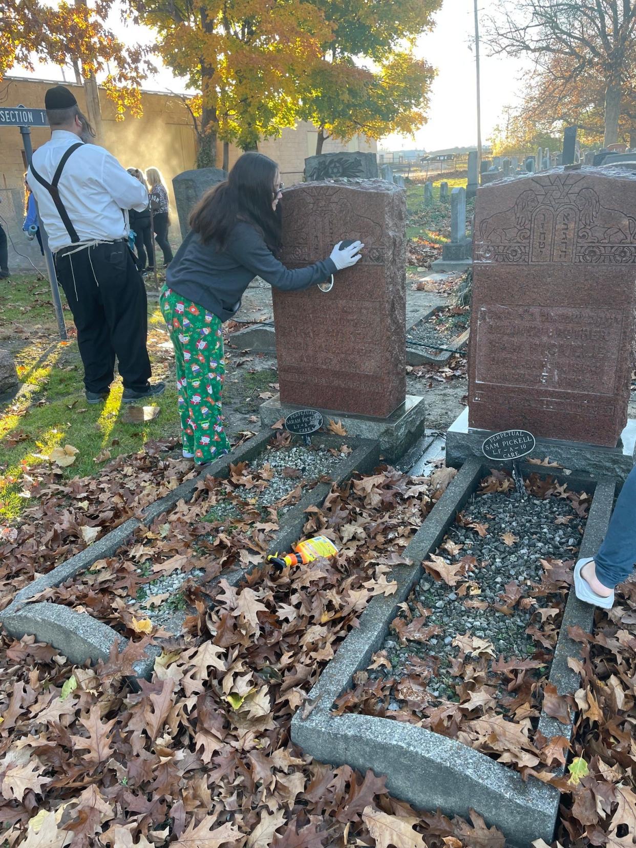 Volunteers removed graffiti that included swastikas at a Jewish Cemetery in Brooklyn, near Cleveland, on Sunday.