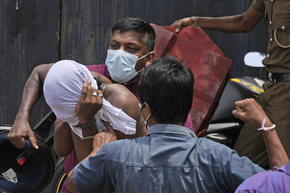 An anti-government protestor, left, is roughed up Sri Lankan government supporters outside prime minister's office in Colombo, Sri Lanka, Monday, May 9, 2022. Sri Lankan Prime Minister Mahinda Rajapaksa resigned Monday following weeks of protests demanding that he and his brother, the president, step down over the country’s worst economic crisis in decades, an official said. (AP Photo/Eranga Jayawardena)