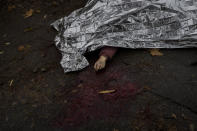 The body of a woman killed during a Russian attack is covered with an emergency blanket before being transported to the morgue in Kherson, southern Ukraine, Friday, Nov. 25, 2022. (AP Photo/Bernat Armangue)