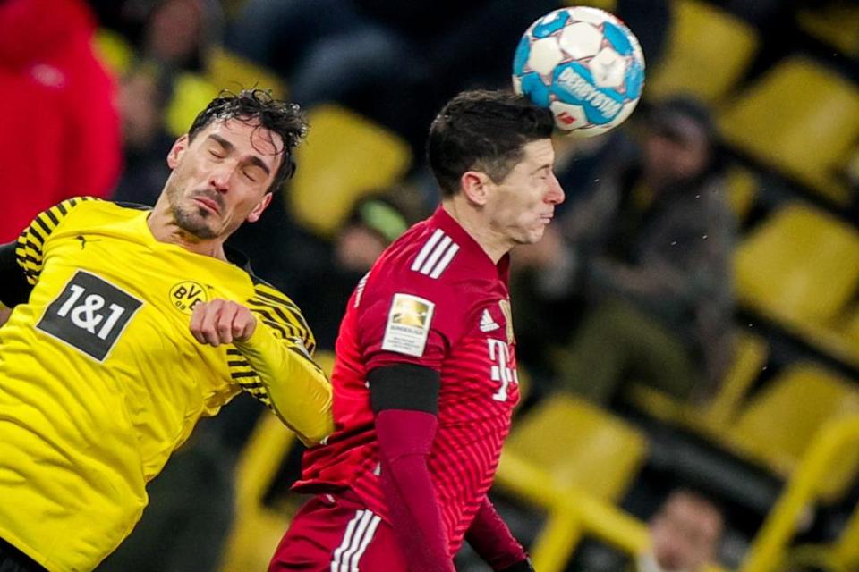 Bayern’s Robert Lewandowski (right)wins a header against his former teammate Mats Hummels.